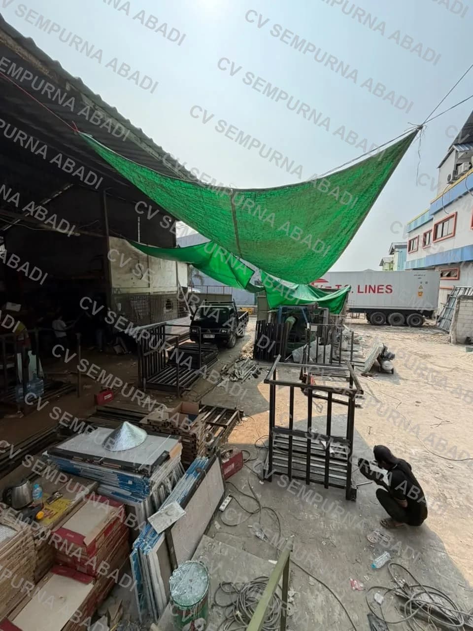 Halaman bengkel dengan rangka besi yang sedang dikerjakan