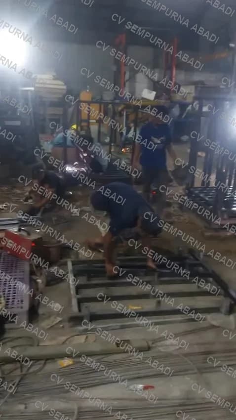 Tim mengelas rangka alas di bengkel