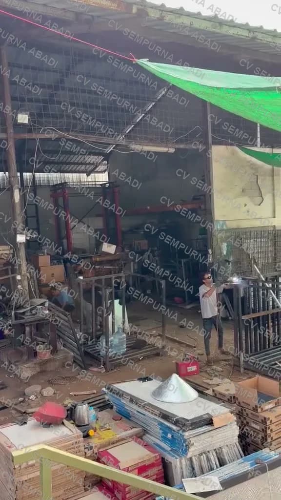 Tim merakit rangka keranjang di halaman bengkel
